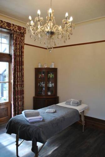 a bedroom with a bed and a chandelier at Eta's Manor @ Brooklands in Maryport