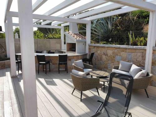 a patio with a table and chairs and a fireplace at Casa Su Soli Sardu 10 - Mit Blick aufs Meer! in La Ciaccia