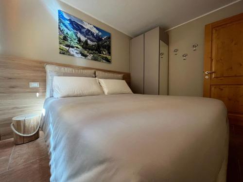 Villa dʼAllegnoにあるChalet La Stella Alpinaのベッドルーム1室(白い大型ベッド1台付)