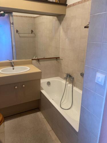 La salle de bains est pourvue d'un lavabo et d'une baignoire à côté d'un lavabo. dans l'établissement CANNES Front de mer, à Cannes