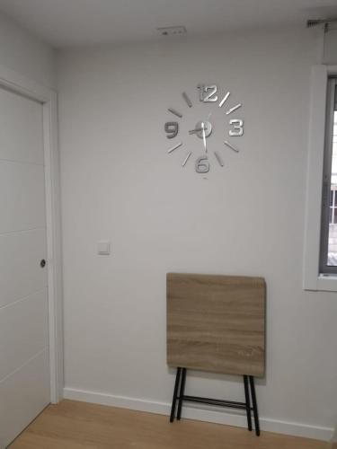 a clock on a wall next to a chair at Ideal parejas in Moaña
