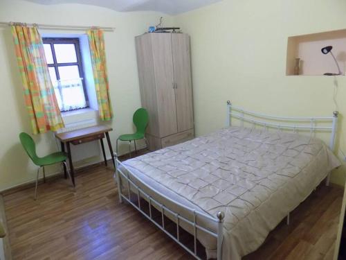 a bedroom with a bed and a desk and a window at ROSE COTTAGE (sleeps 4) in Chlum u Třeboně