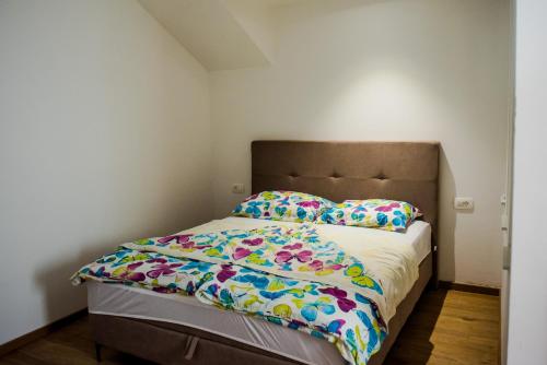 a bedroom with a bed with colorful sheets and pillows at Apartments Joja in Međugorje