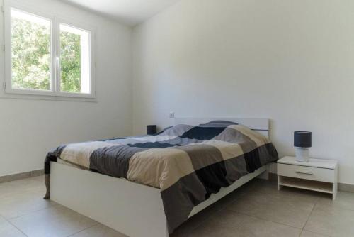 une chambre blanche avec un lit et une fenêtre dans l'établissement Villa 4 personnes U Pinu, piscine partagée, 6 kms de porto vecchio, à Porto-Vecchio