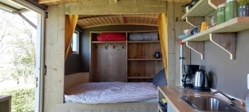małą sypialnię w małym domku z łóżkiem w obiekcie Slaaphuisjes op wielen BuitenWedde Westerwolde w mieście Wedde