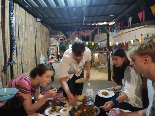 拜縣的住宿－Topp paiway hostel，一群人站在桌子旁吃食物