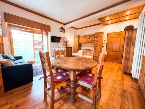 a dining room with a wooden table and chairs at Green Park Studio Courmayeur in Courmayeur