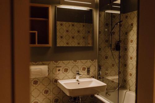 La salle de bains est pourvue d'un lavabo et d'une douche. dans l'établissement Wallerei Walchensee, à Lac de Walchen