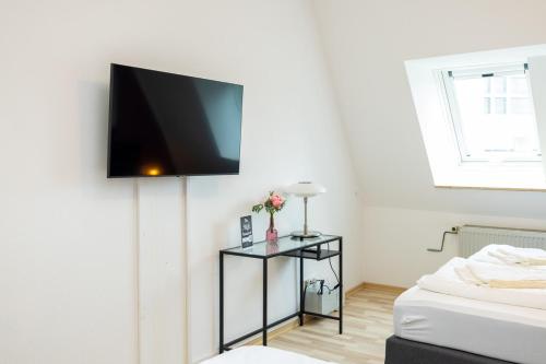 Zimmer mit einem Flachbild-TV an der Wand in der Unterkunft Modernes Apartment in der Innenstadt in Würzburg
