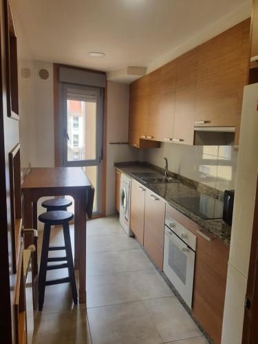 eine Küche mit einer Theke und einem Hocker darin in der Unterkunft Maravilloso apartamento en Villagarcia de Arosa in Vilagarcia de Arousa