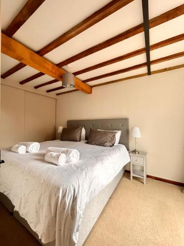 1 dormitorio con 1 cama blanca grande y techos de madera en The Annexe Headcorn, en Headcorn