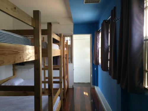 a room with two bunk beds and a blue wall at Mapping Hostel in Chiang Mai