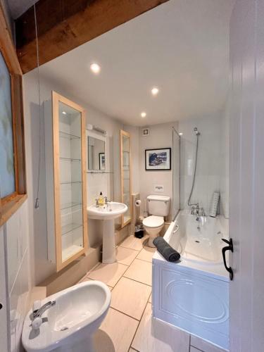 a bathroom with a sink and a tub and a toilet at The Annexe Headcorn in Headcorn