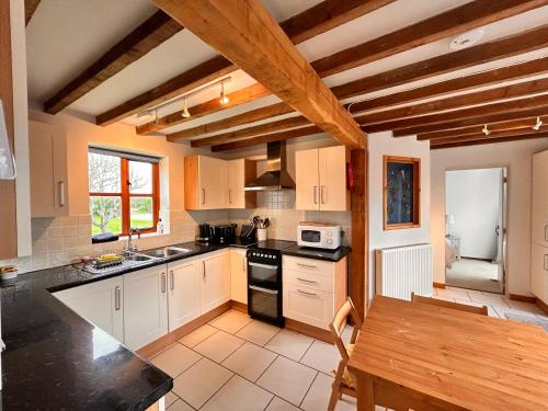 a kitchen with white cabinets and black counter tops at The Annexe Headcorn in Headcorn