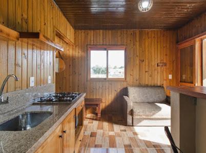 een keuken met een wastafel en een bank in een kamer bij Pousada Canyons do Sul in Praia Grande