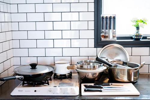 a kitchen counter with pots and pans on a stove at FLEX BEACH HOUSE in Gushiken