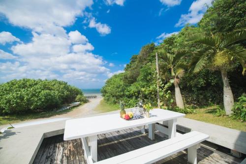 a white table with a bowl of fruit on top of a road at FLEX BEACH HOUSE in Gushiken