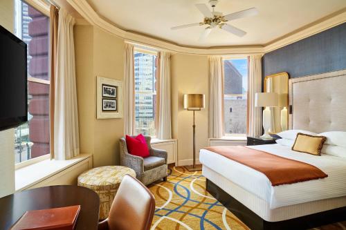 a hotel room with a bed and a desk and window at The Brown Palace Hotel and Spa, Autograph Collection in Denver