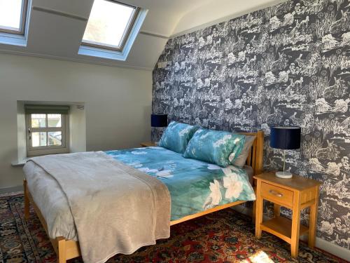 1 dormitorio con 1 cama y pared en blanco y negro en Mai's Cottage Suite - Charming Holiday Rental, en Kilmallock