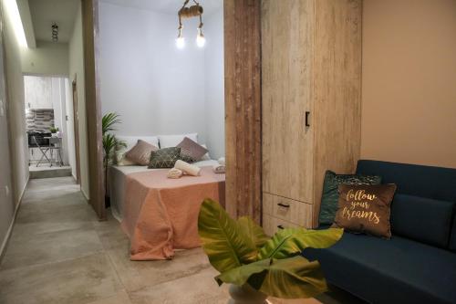 - un salon avec un lit et un canapé bleu dans l'établissement MSK Rotonda Studio 2, à Thessalonique