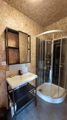 a bathroom with a sink and a shower at De terre et de bois. 