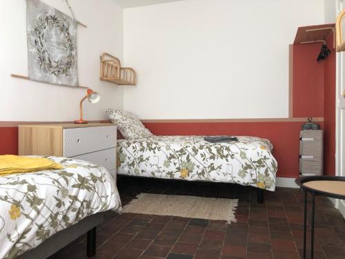 1 dormitorio con 2 camas, escritorio y silla en NATIFRIENDLY-Appartement centre historique avec jardin IDEAL FAMILLE, en Bellême
