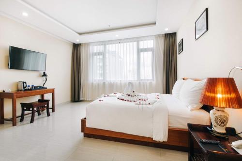 een hotelkamer met een groot bed en een bureau bij Martin Ho Danang hotel & apartment in Da Nang