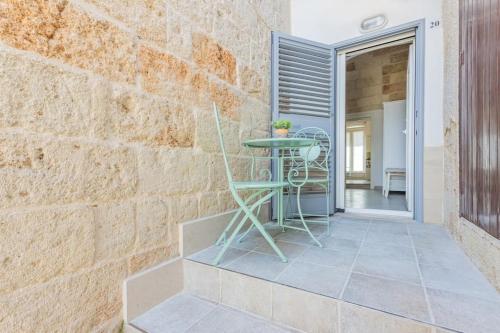 a patio with a table and a brick wall at Extravacanza Spiraglio di Mare in Polignano a Mare