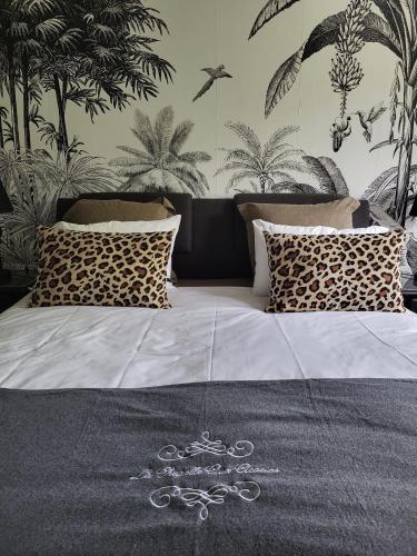 a bedroom with a bed with plants on the wall at La Chapelle aux Acacias in Caucalières
