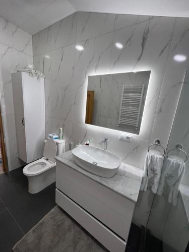bagno bianco con lavandino e servizi igienici di Immanuel Villa a Ptghni