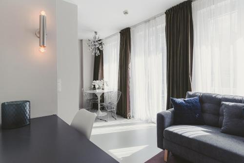 sala de estar con sofá, mesa y ventana en HeyMi Apartments Mondschein, en Viena