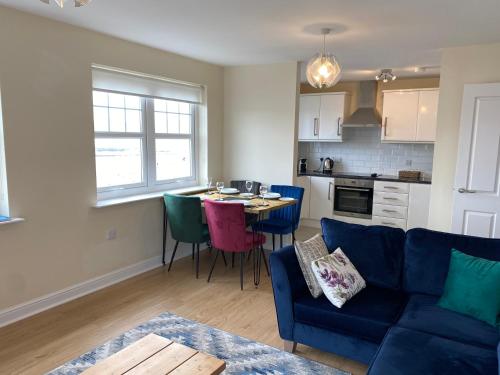 a living room with a blue couch and a table at Harbourside in Garlieston