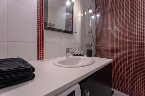 a bathroom with a sink and a red tiled shower at Atlantic Selection - Appart Baiona - Au coeur de Bayonne in Bayonne