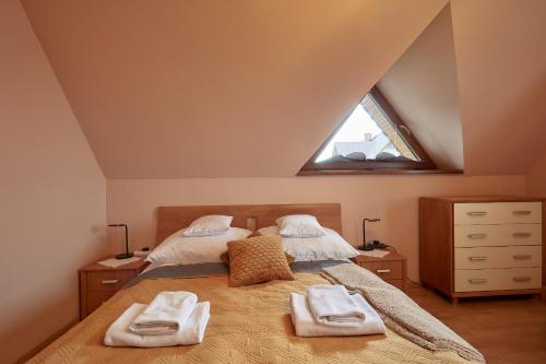 a bedroom with a bed with two towels on it at Apartament 1010 m in Ząb