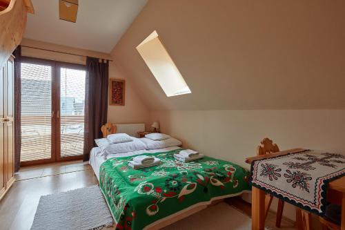 a bedroom with a bed with a green blanket at Apartament 1010 m in Ząb