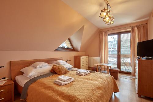 a bedroom with a bed with two towels on it at Apartament 1010 m in Ząb
