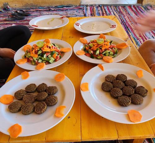 una mesa de madera con platos de comida. en Full Moon Camp Sinai en Nuweiba
