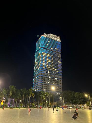 a tall building at night with people in front of it at TMS in Quy Nhon