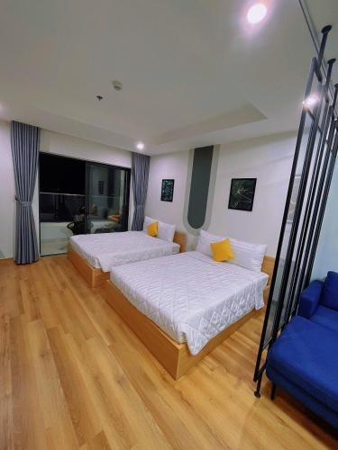 a bedroom with two beds and a blue couch at TMS in Quy Nhon
