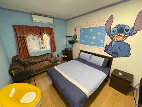 a bedroom with a bed with a cartoon rabbit on the wall at Green Island Xinmanyuan綠島馨滿園 in Green Island