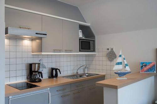 a kitchen with a sink and a microwave at Villa Westend in Norderney