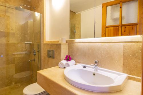 Un baño con lavabo, ducha e inodoro. en Korsan Apartments No:4, en Kas
