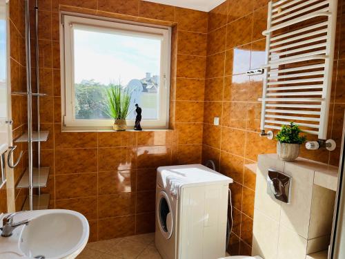 een badkamer met een toilet, een wastafel en een raam bij Apartament Słoneczny na Wydmie in Ustka