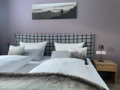 Un dormitorio con dos camas con almohadas blancas. en hus9, en Mittelberg
