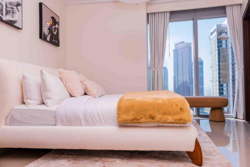 a white couch in a room with a large window at Majestay - Luxury Living in Dubai