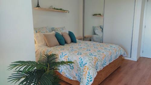 um quarto com uma cama com almofadas e uma planta em Viewpoint - Lovely Nature View em Machico