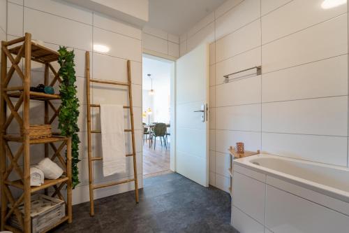 a bathroom with white walls and a tub and a sink at dreamcation Apartments - Altstadt Kelheim in Kelheim