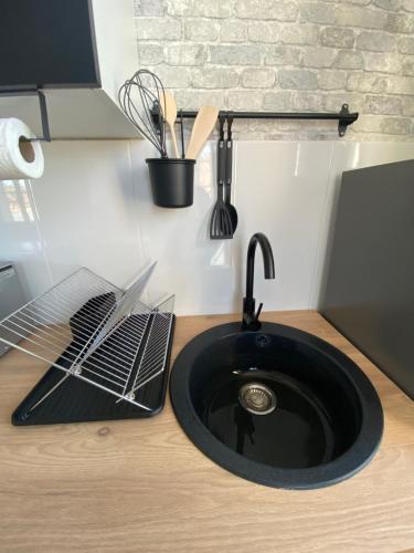 a black sink in a kitchen next to a counter at Grey Cosy in Louviers