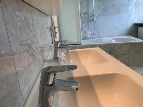 a bathroom with a sink with a faucet and a tub at Villa mit Pool und Grillplatz in Regensburg in Regensburg