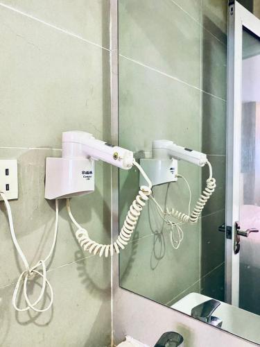 a white phone on a wall next to a mirror at Sri Langit Hotel KLIA, KLIA 2 & F1 in Sepang
